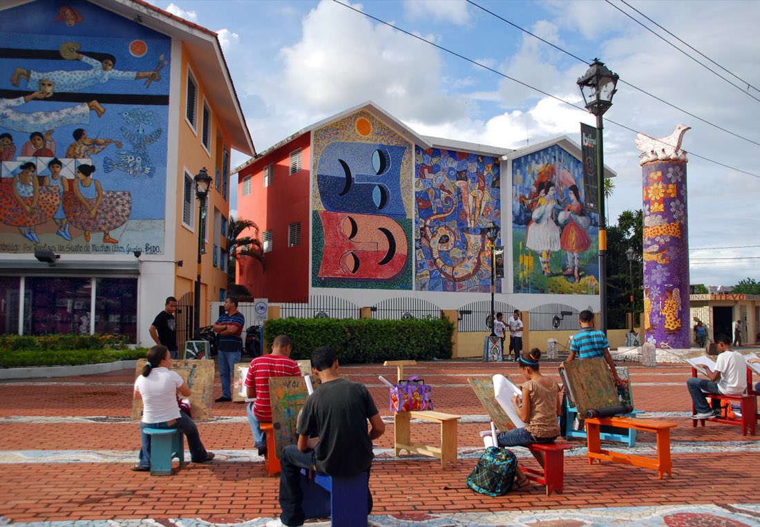Personas dibujando frente a los murales de la Plaza de la Cultura de Bonao